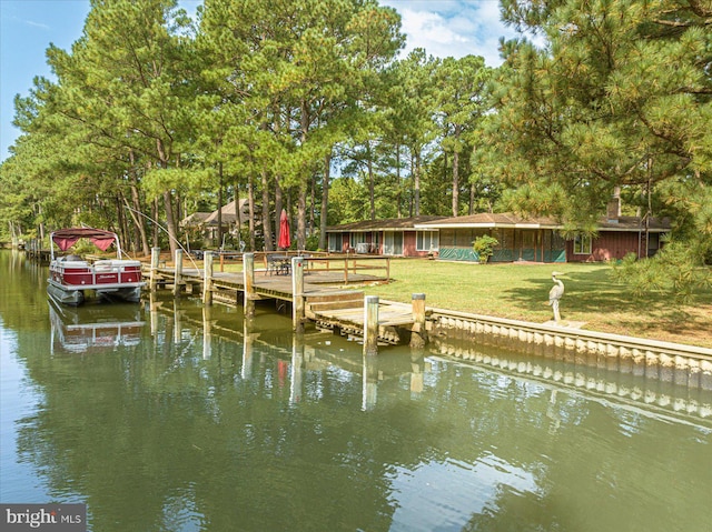 view of dock featuring a water view and a yard