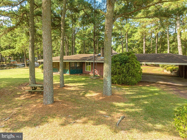 view of front of home with an attached carport and a front yard