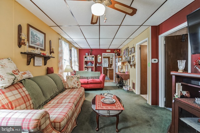 carpeted living room with ceiling fan and a drop ceiling