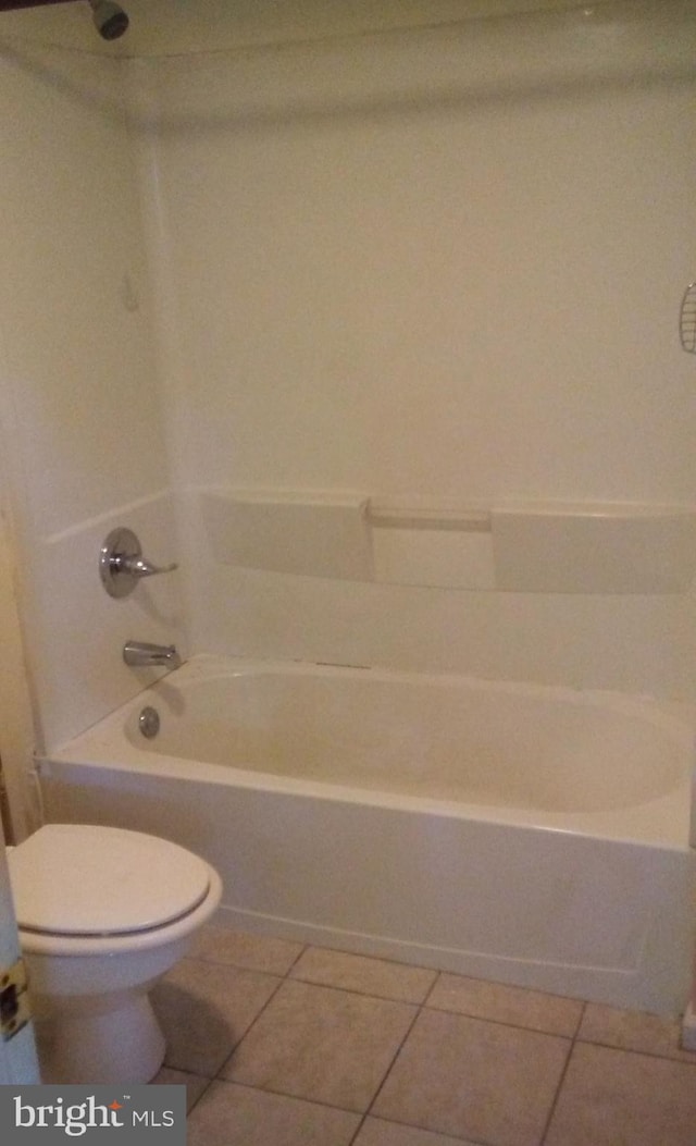 bathroom featuring bathing tub / shower combination, tile patterned floors, and toilet