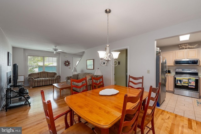 dining area with ceiling fan with notable chandelier and light tile patterned floors