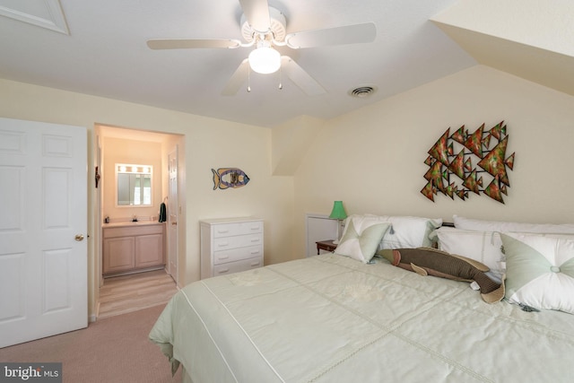 carpeted bedroom with ceiling fan, vaulted ceiling, and ensuite bath