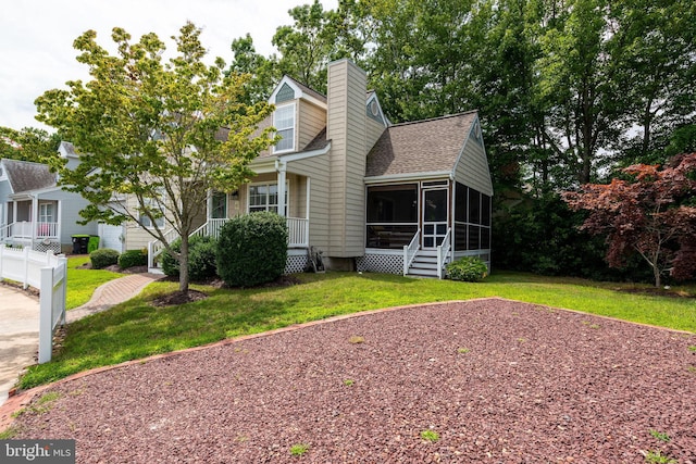 view of front of home with a front lawn and a sunroom