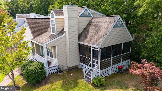 exterior space featuring a yard and a sunroom