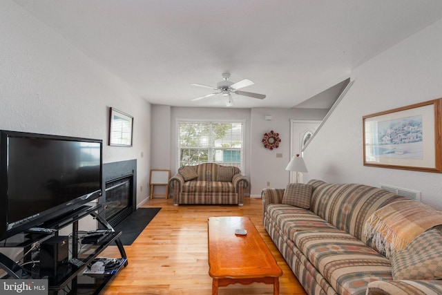 living room with ceiling fan and light wood-type flooring