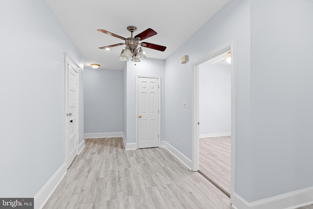 spare room with light wood-style flooring, baseboards, and a ceiling fan