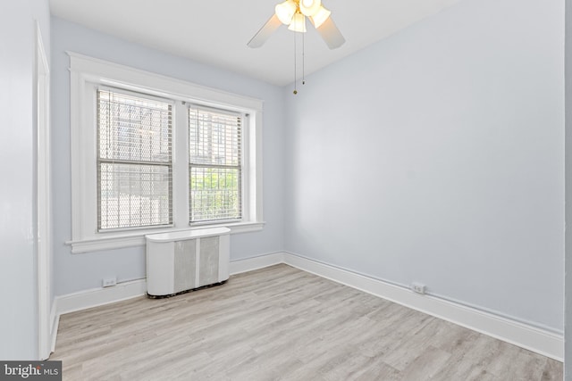 empty room featuring ceiling fan, light wood-type flooring, and baseboards