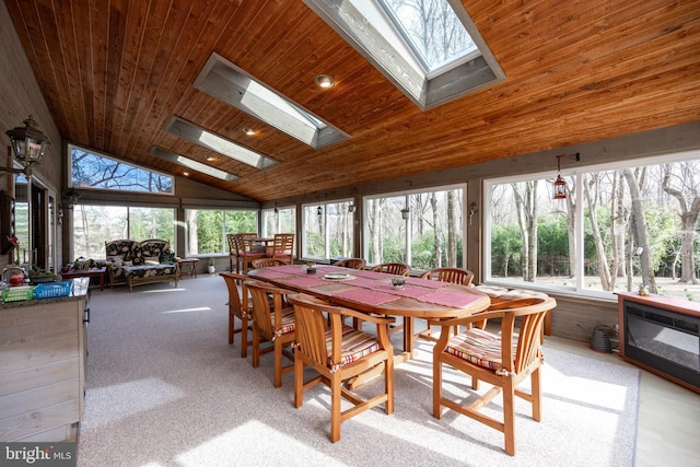 sunroom with vaulted ceiling with skylight and wooden ceiling