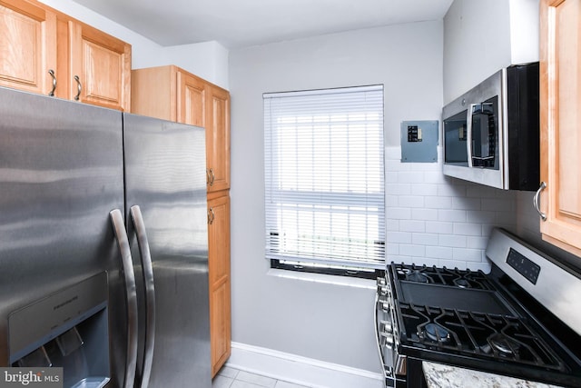 kitchen with light tile patterned flooring, appliances with stainless steel finishes, and decorative backsplash