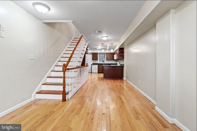 stairs featuring hardwood / wood-style flooring and sink