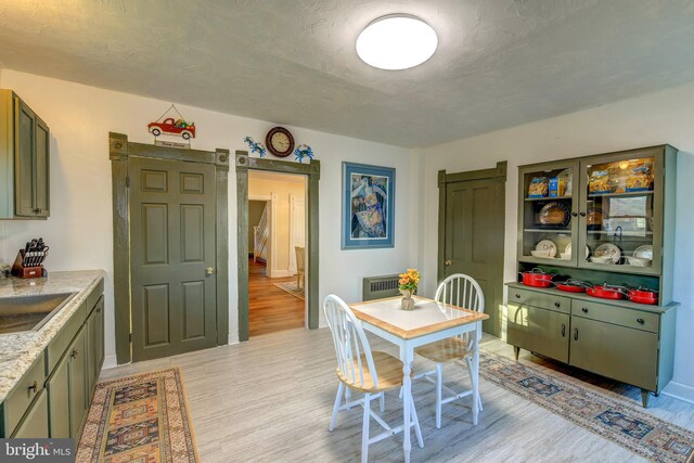 dining space with sink and light hardwood / wood-style floors