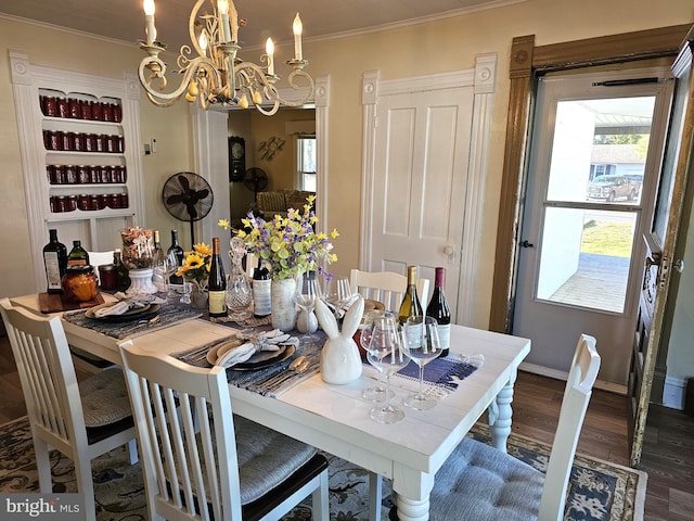 dining room featuring dark wood-type flooring, a chandelier, and ornamental molding