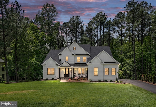 modern inspired farmhouse with a yard and covered porch