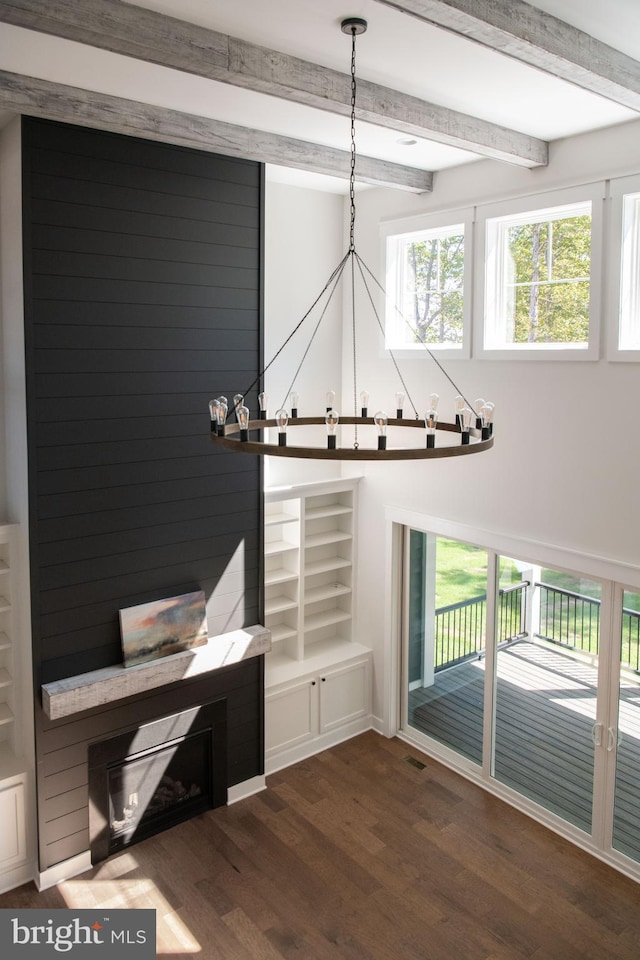 interior space featuring beamed ceiling, built in features, dark hardwood / wood-style floors, and a healthy amount of sunlight