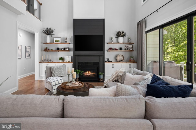 living room with a high ceiling and wood-type flooring