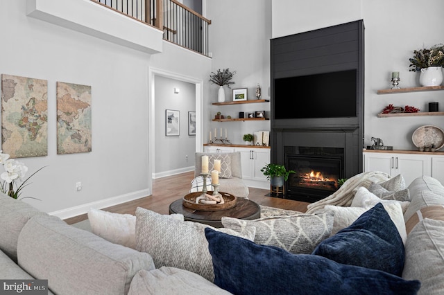 living room featuring hardwood / wood-style floors and a towering ceiling