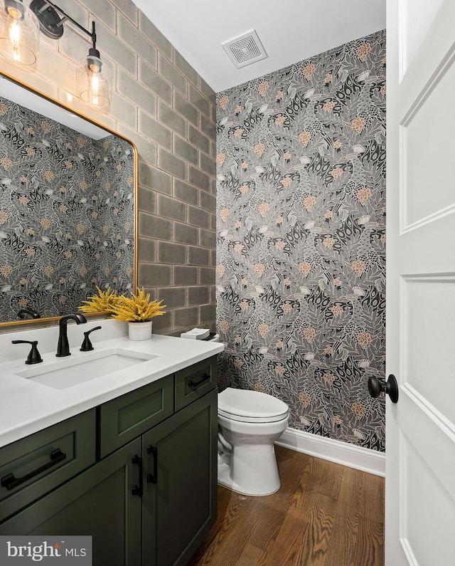 bathroom with vanity, hardwood / wood-style floors, and toilet