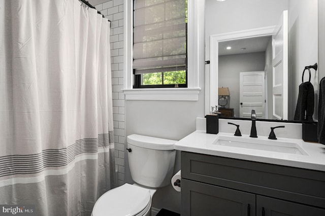 bathroom featuring walk in shower, vanity, and toilet