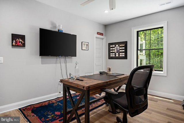 home office featuring light hardwood / wood-style flooring and ceiling fan