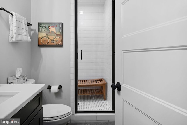 bathroom featuring an enclosed shower, vanity, and toilet