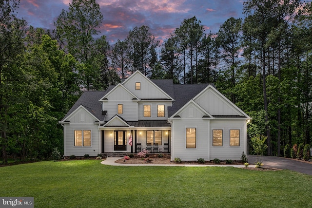 modern farmhouse with a yard and covered porch