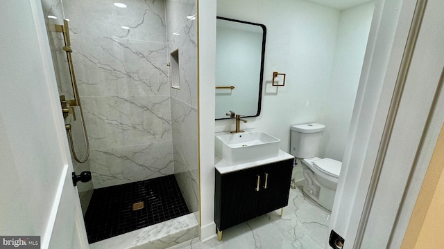 bathroom with tile patterned flooring, toilet, tiled shower, and vanity