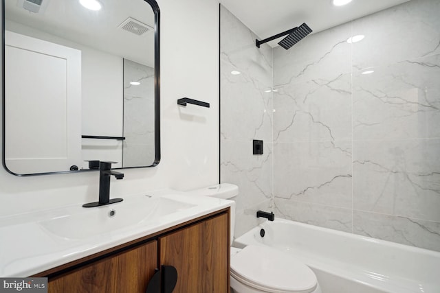 full bathroom featuring tiled shower / bath, vanity, and toilet