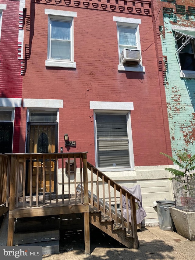 rear view of house featuring cooling unit and a deck