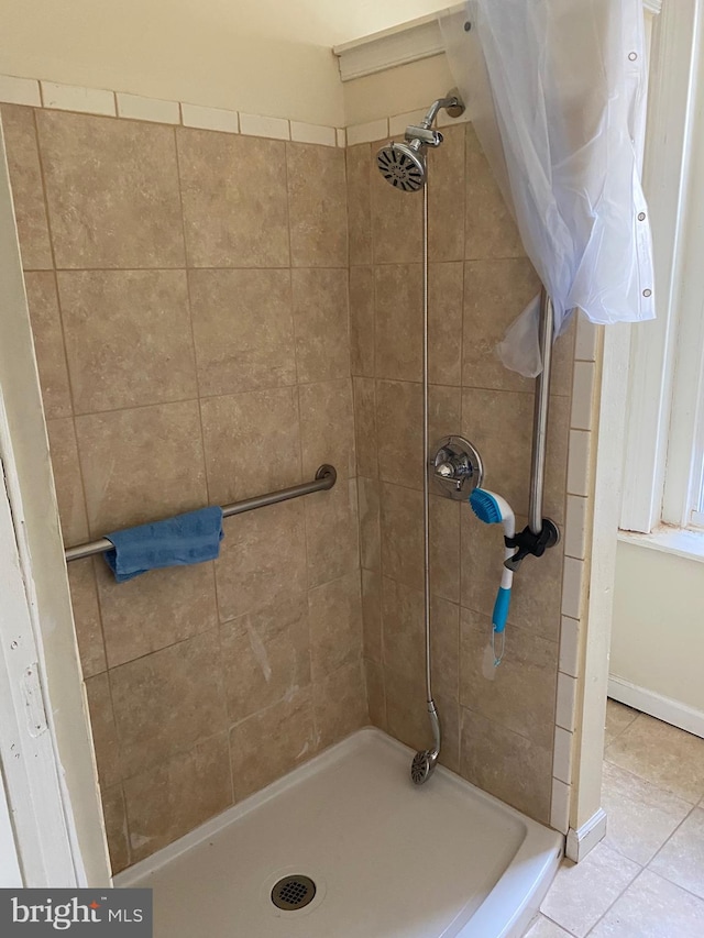 bathroom featuring a tile shower and tile patterned flooring