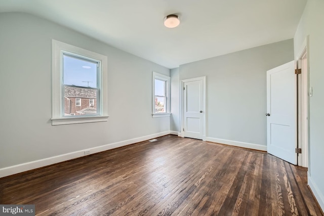 unfurnished bedroom with vaulted ceiling and dark hardwood / wood-style flooring