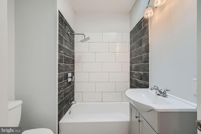 full bathroom with toilet, vanity, and tiled shower / bath