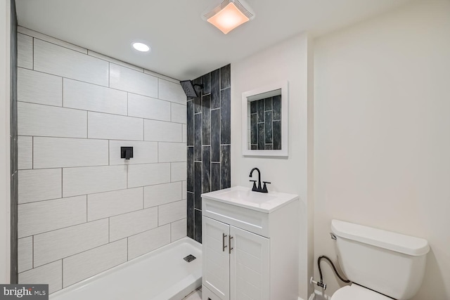 bathroom with vanity, toilet, and tiled shower