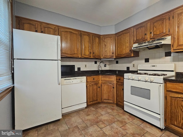 kitchen with light tile patterned floors, backsplash, white appliances, and sink