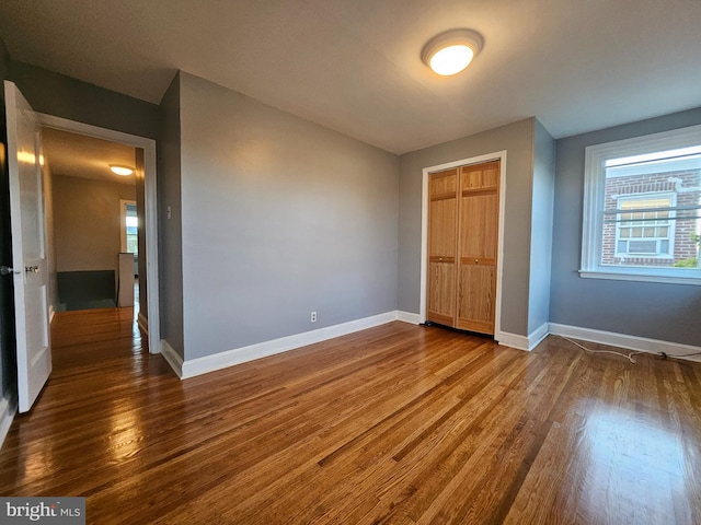 unfurnished bedroom with hardwood / wood-style floors and a closet