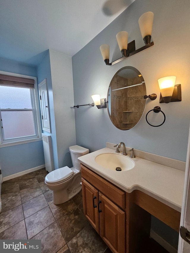 bathroom with vanity, radiator, toilet, and tile patterned flooring