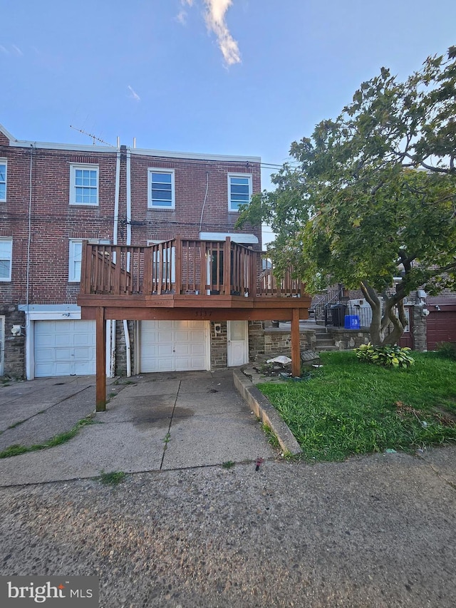 rear view of house with a garage and a wooden deck