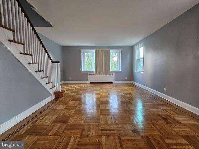 interior space with radiator heating unit and parquet flooring