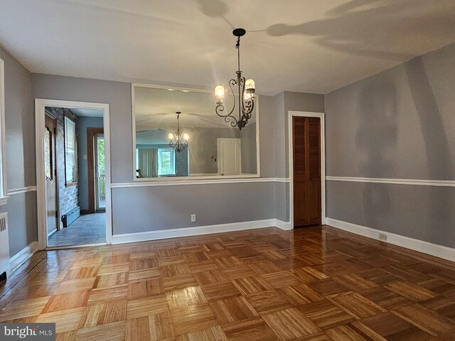 unfurnished dining area featuring parquet flooring and an inviting chandelier