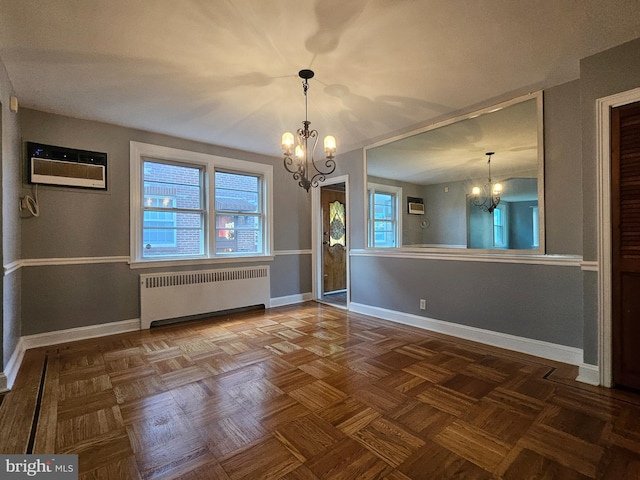 unfurnished dining area with radiator, a wall unit AC, a chandelier, and dark parquet floors