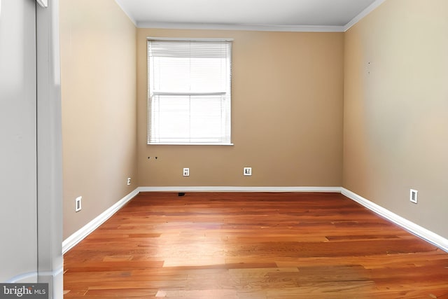 spare room with ornamental molding and hardwood / wood-style floors