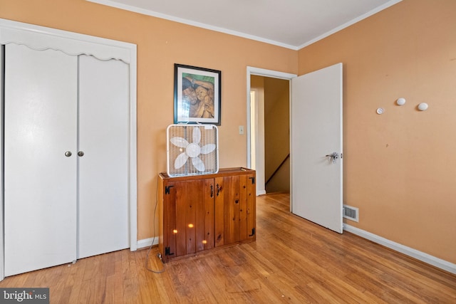 bedroom with crown molding and light hardwood / wood-style flooring