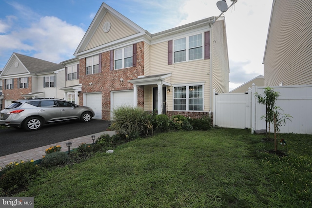 view of front of home with aphalt driveway, brick siding, an attached garage, a front yard, and fence