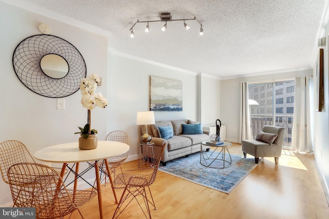 living room with hardwood / wood-style flooring, crown molding, and a textured ceiling