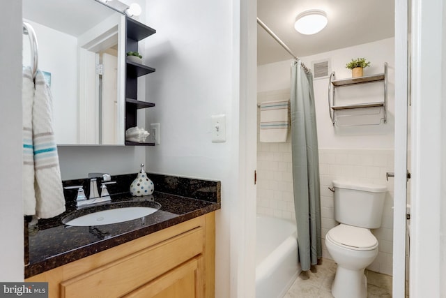 full bathroom featuring shower / tub combo with curtain, tile walls, tile patterned flooring, vanity, and toilet