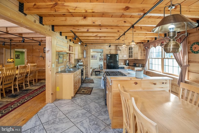 kitchen with light brown cabinets, light tile patterned floors, beam ceiling, black appliances, and sink