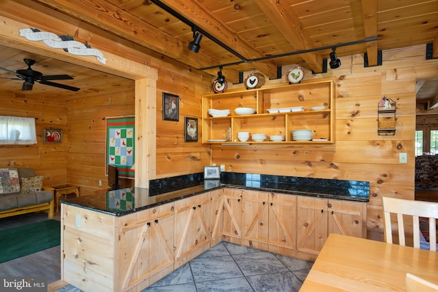 kitchen featuring wooden walls, ceiling fan, rail lighting, wooden ceiling, and beamed ceiling