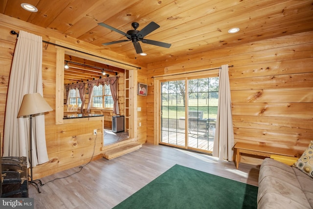 unfurnished bedroom with access to outside, wood walls, wooden ceiling, and light hardwood / wood-style floors