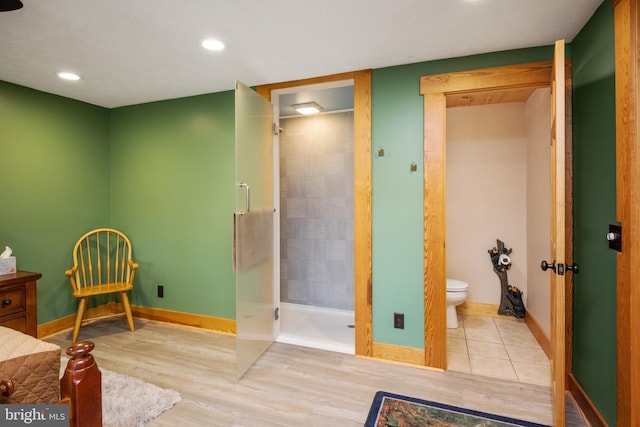 full bathroom featuring toilet, wood finished floors, recessed lighting, a shower stall, and baseboards