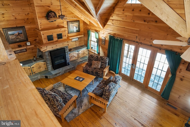 living room featuring lofted ceiling with beams, hardwood / wood-style floors, ceiling fan, and a wealth of natural light