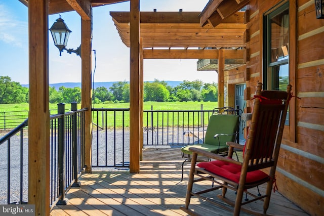 wooden terrace featuring a pergola and a lawn